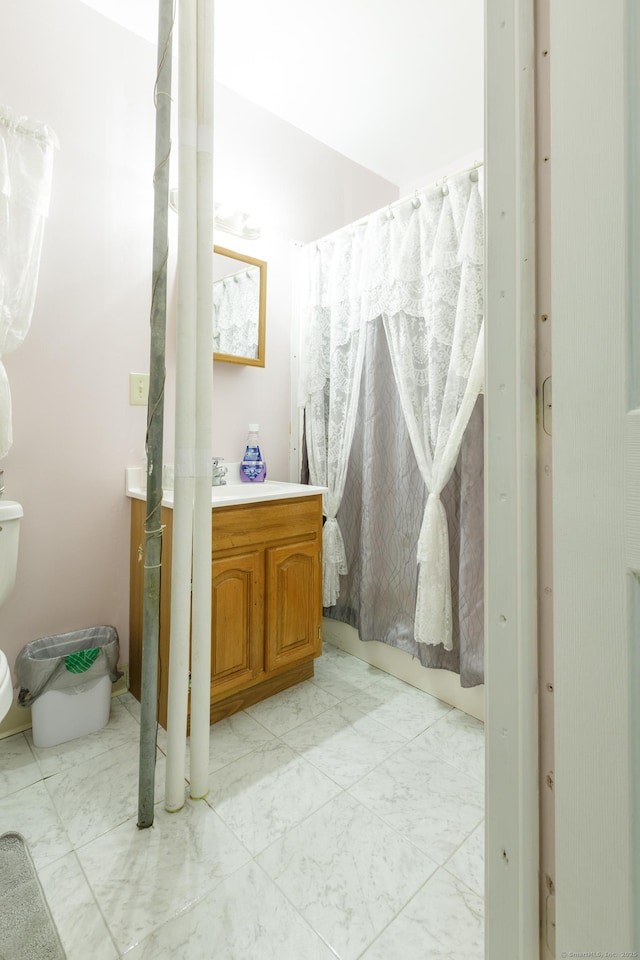 full bathroom featuring marble finish floor, vanity, and toilet