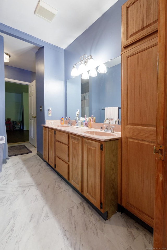 bathroom with a sink, visible vents, double vanity, and marble finish floor