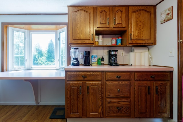 kitchen featuring tasteful backsplash, brown cabinets, light countertops, and wood finished floors