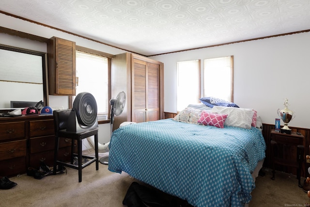 carpeted bedroom featuring a closet, an ornate ceiling, multiple windows, and crown molding