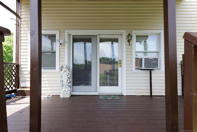 property entrance with a deck and cooling unit