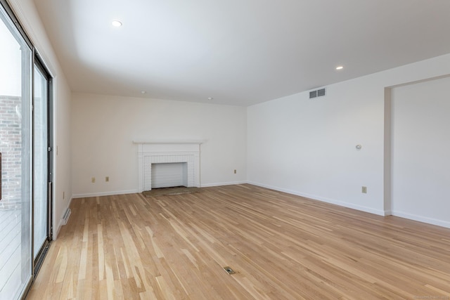 unfurnished living room featuring light wood finished floors, visible vents, baseboards, recessed lighting, and a fireplace