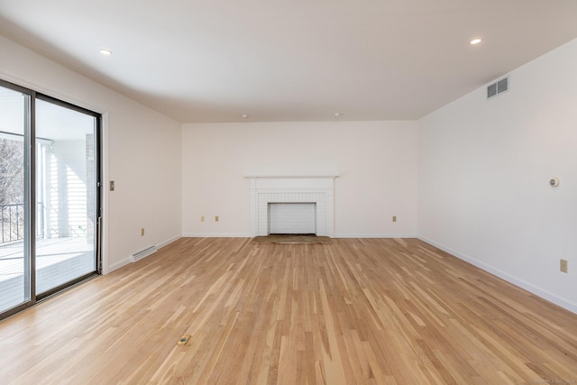 unfurnished living room with a fireplace, baseboards, visible vents, and light wood finished floors