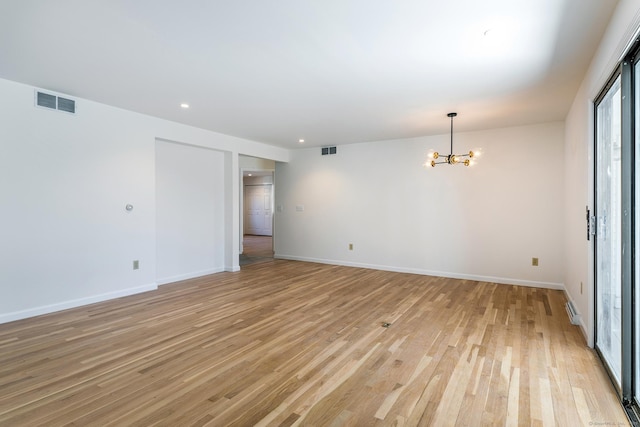 unfurnished room featuring light wood-style flooring, baseboards, visible vents, and a chandelier