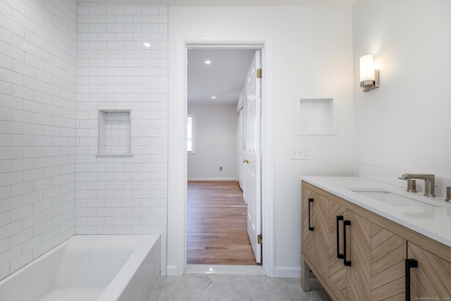 full bath featuring tile patterned flooring, bathing tub / shower combination, vanity, and baseboards