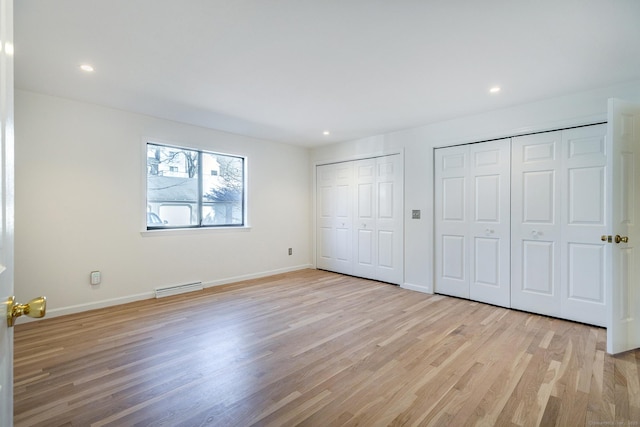 unfurnished bedroom with light wood finished floors, recessed lighting, baseboards, and multiple closets