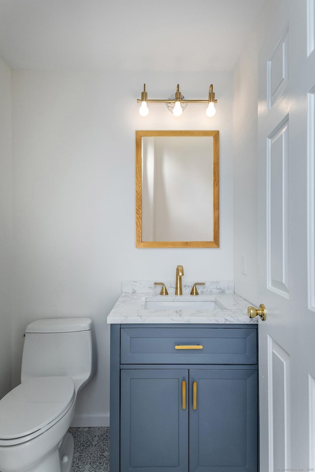 half bathroom with toilet, vanity, and baseboards