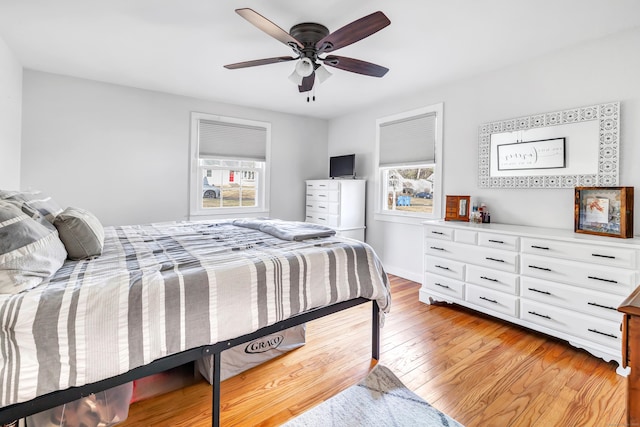 bedroom featuring a ceiling fan, light wood-type flooring, and baseboards