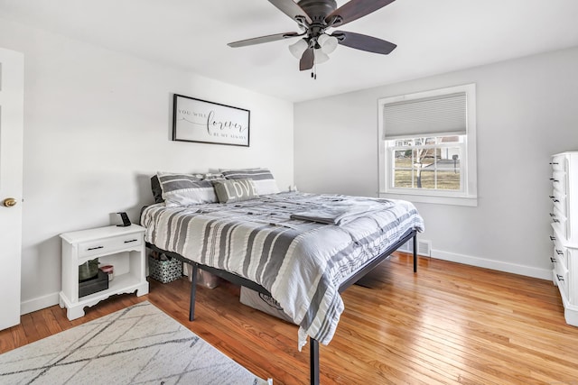 bedroom with a ceiling fan, visible vents, light wood-style floors, and baseboards