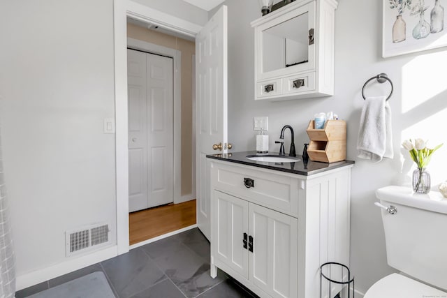 bathroom featuring visible vents, toilet, and vanity