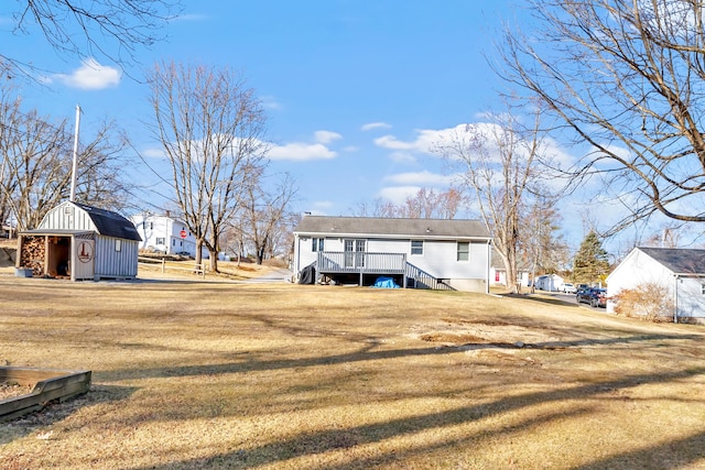 exterior space with an outbuilding, a yard, stairs, a storage unit, and a deck