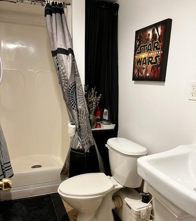 full bathroom featuring a sink, toilet, and a shower stall