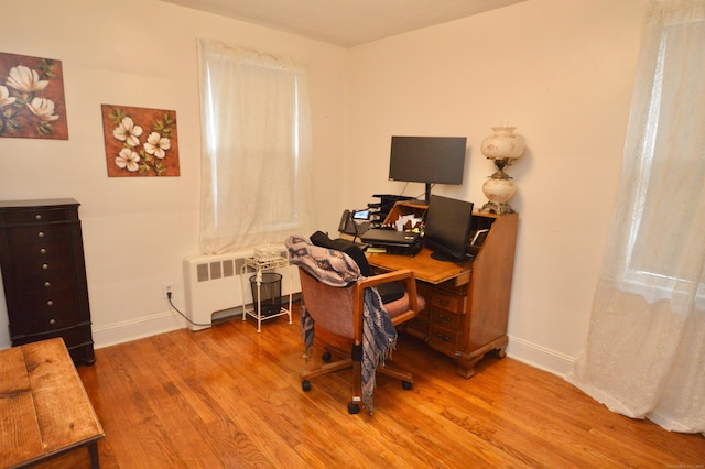 office featuring radiator heating unit, wood finished floors, and baseboards