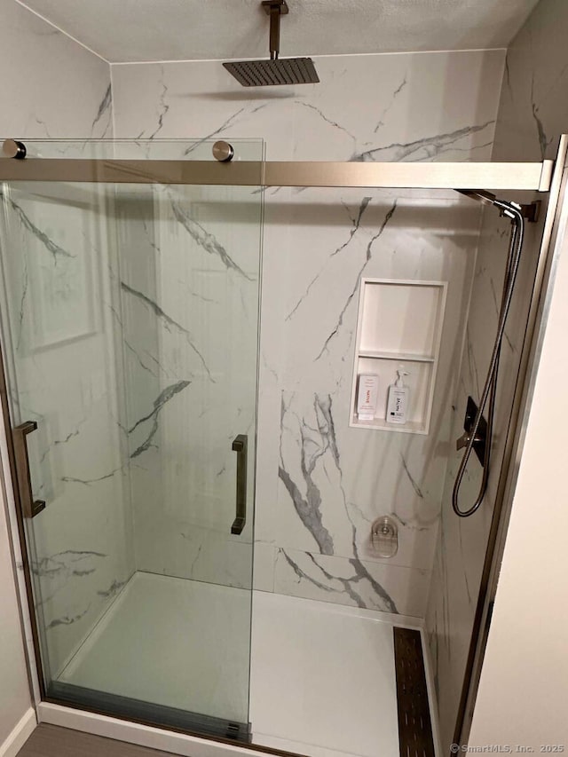 bathroom with a marble finish shower