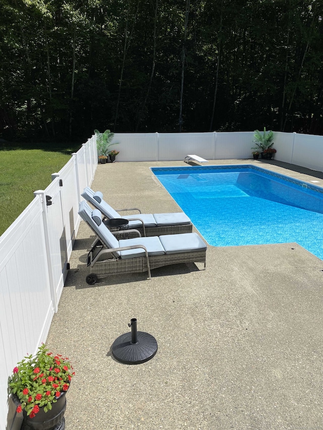 view of pool featuring a patio, a fenced in pool, a diving board, and a fenced backyard