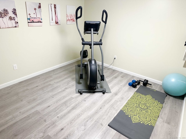 workout area featuring wood finished floors and baseboards