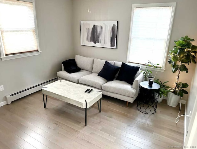 living area with hardwood / wood-style floors, baseboards, and a baseboard radiator