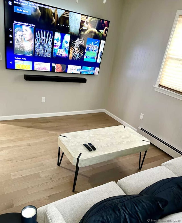 living area with wood finished floors, baseboards, and a baseboard radiator