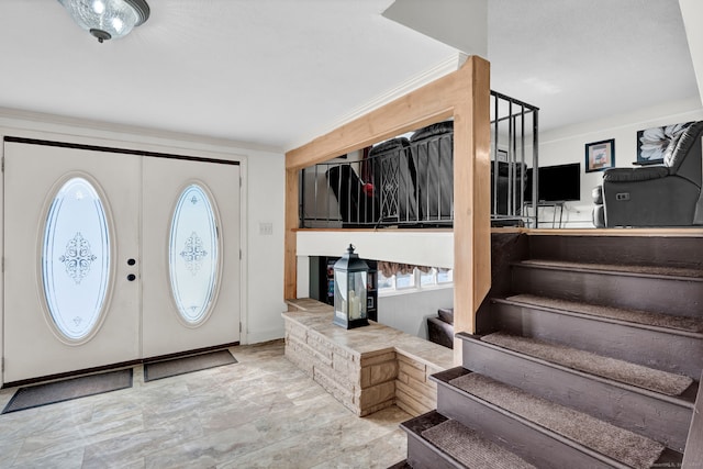 entryway featuring stairs and crown molding