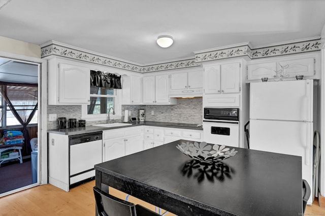 kitchen featuring a sink, white appliances, under cabinet range hood, and white cabinets