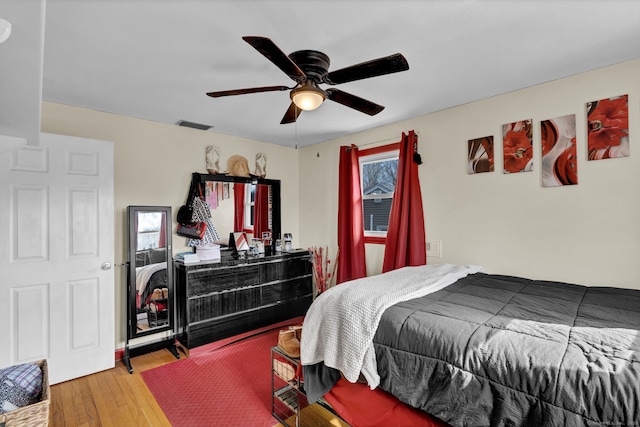 bedroom featuring visible vents, hardwood / wood-style floors, and a ceiling fan