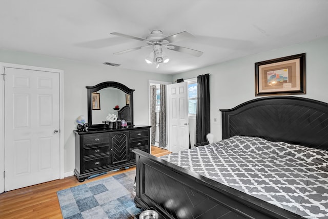 bedroom featuring visible vents, light wood-style floors, and a ceiling fan