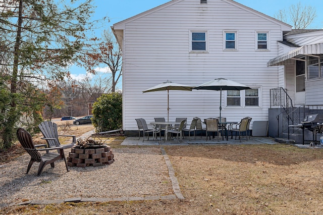 rear view of property featuring a patio area and a fire pit