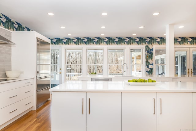 kitchen featuring a sink, light countertops, white cabinets, modern cabinets, and built in fridge