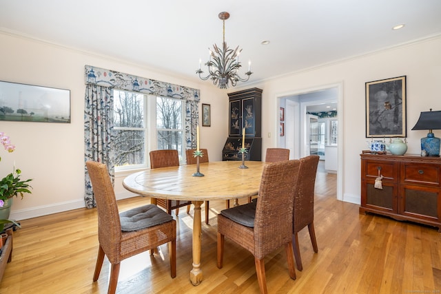 dining space featuring light wood-type flooring, recessed lighting, crown molding, baseboards, and a chandelier