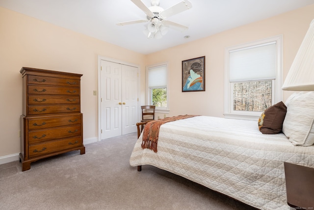 bedroom with a closet, ceiling fan, baseboards, and carpet