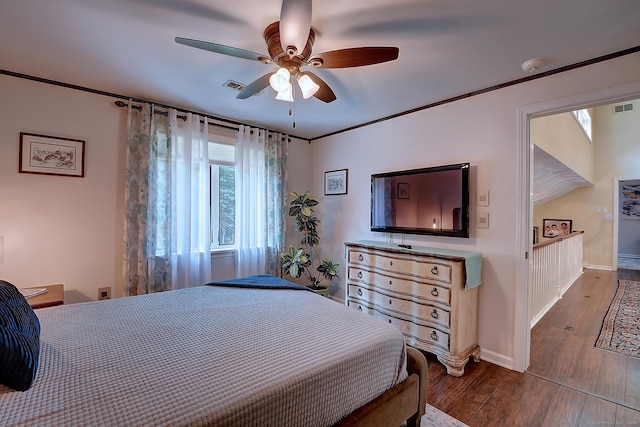 bedroom with a ceiling fan, dark wood-style floors, visible vents, baseboards, and crown molding