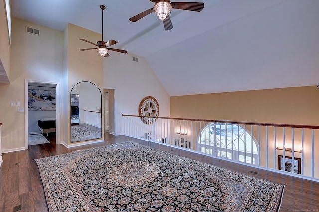 interior space featuring visible vents, baseboards, high vaulted ceiling, and wood finished floors