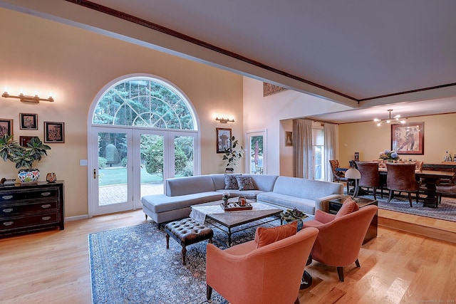 living room featuring a chandelier, light wood-style floors, and ornamental molding