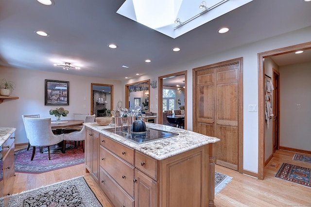 kitchen featuring black electric stovetop, recessed lighting, light wood-type flooring, and a center island