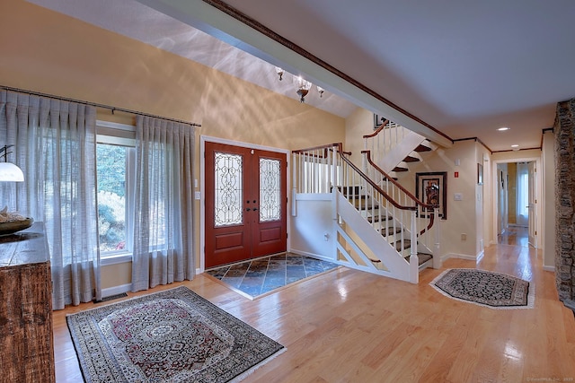 entrance foyer featuring wood finished floors, visible vents, baseboards, stairs, and french doors