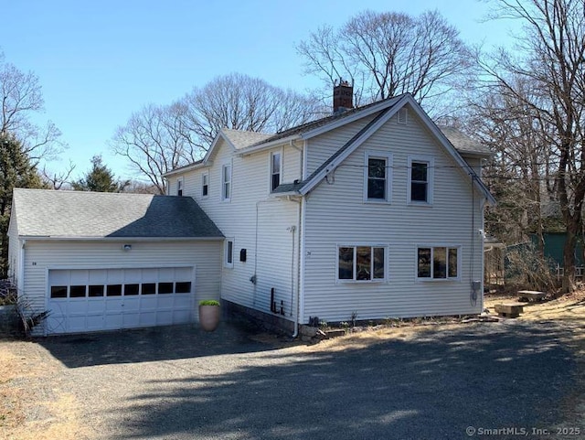 view of home's exterior with a garage and a chimney