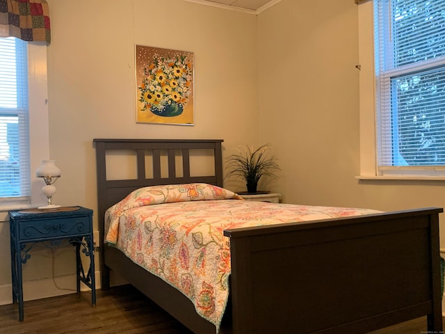 bedroom with crown molding and wood finished floors