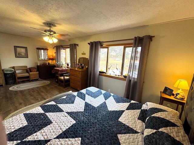 bedroom with a ceiling fan, wood finished floors, and a textured ceiling