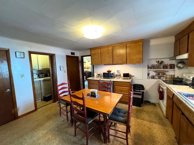 kitchen featuring electric range, brown cabinets, light countertops, and stainless steel microwave