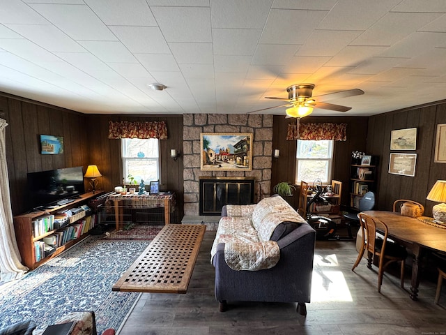 living area featuring plenty of natural light, a ceiling fan, wood finished floors, and a fireplace