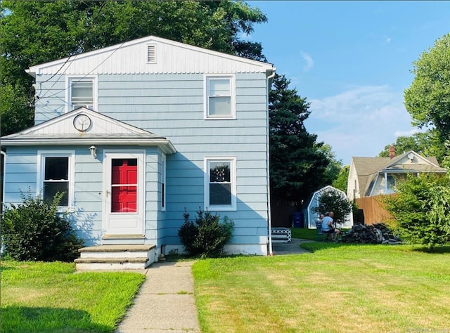 view of front of house with entry steps and a front lawn