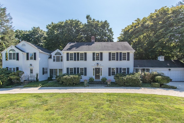 colonial house with a front lawn and a chimney