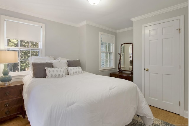 bedroom with light wood-style flooring and crown molding