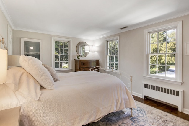 bedroom featuring visible vents, multiple windows, and radiator heating unit