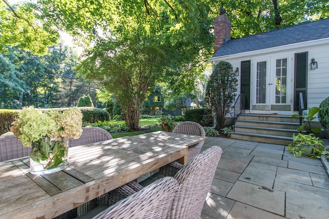 view of patio with entry steps, outdoor dining area, and french doors