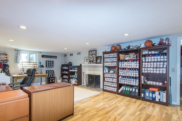 home office featuring recessed lighting, visible vents, wood finished floors, and a fireplace