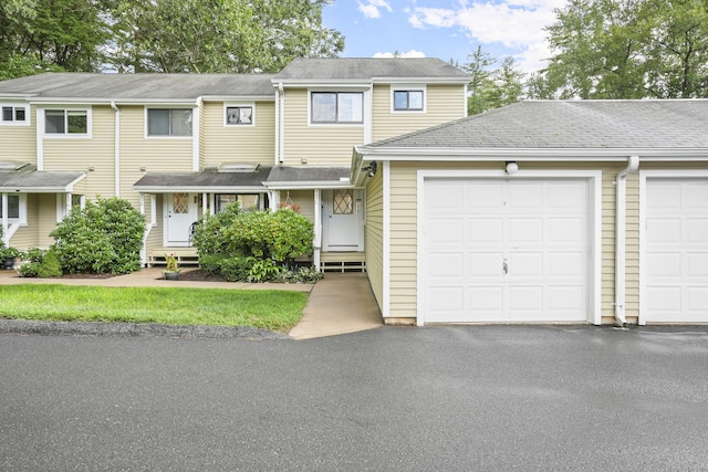 townhome / multi-family property featuring aphalt driveway and an attached garage