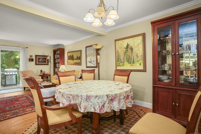 dining room featuring an inviting chandelier, wood finished floors, and ornamental molding