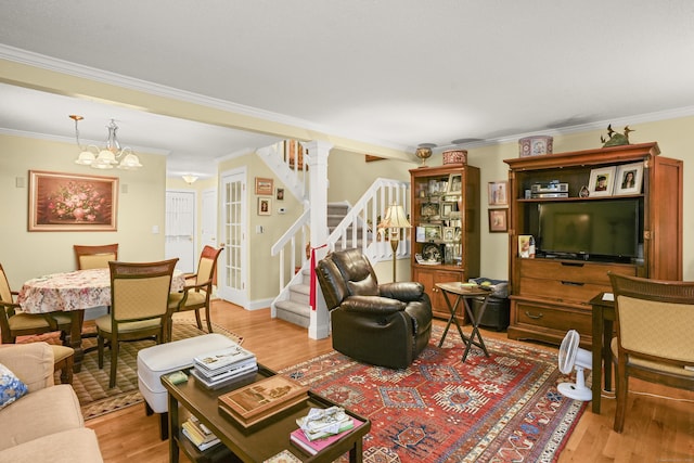 living room featuring light wood-style flooring, crown molding, stairs, and baseboards