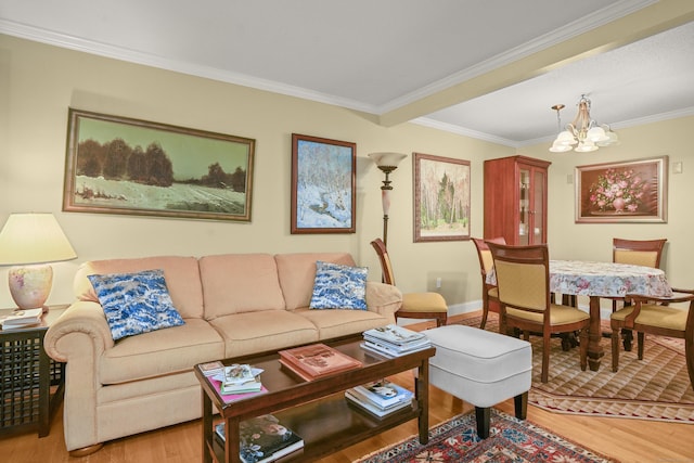 living area featuring a notable chandelier, wood finished floors, baseboards, and ornamental molding